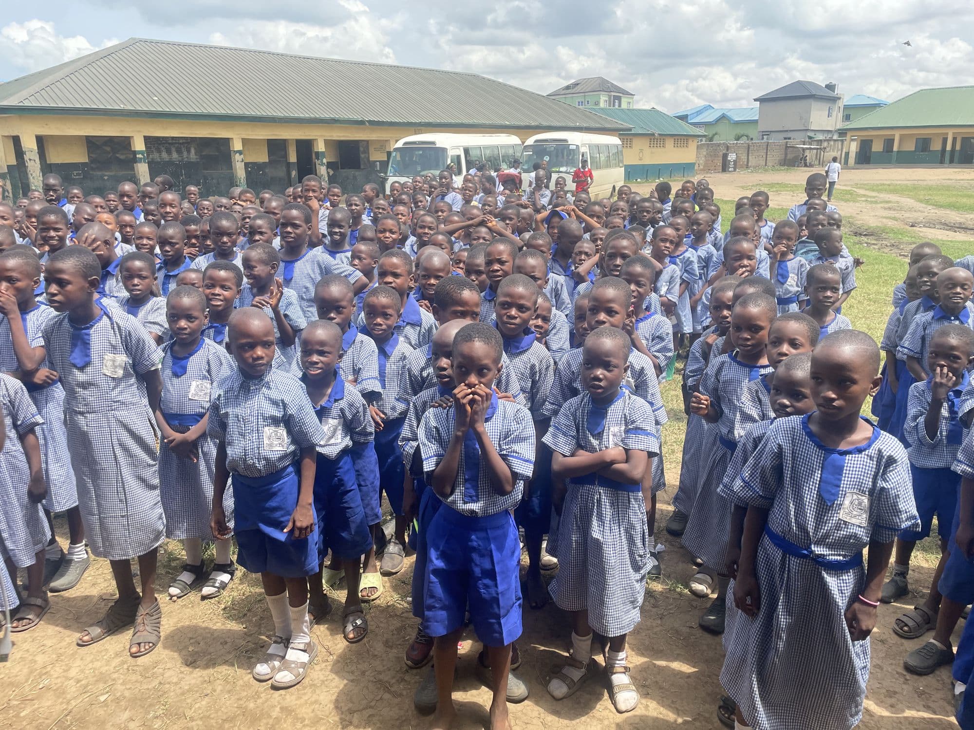 Pupils in blue uniforms gathered in a school yard