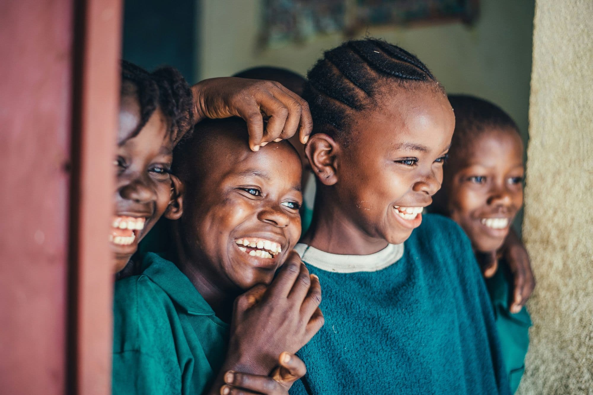 Children in green school jumpers laughing together