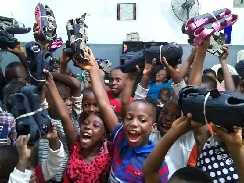 Children holding new sandals above their heads